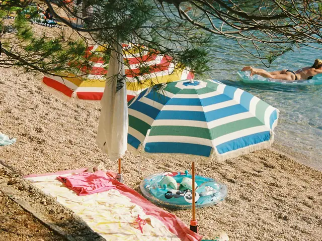 Striped parasols on a pebble beach